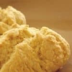 Two buttermilk biscuits are sitting on a brown plate.