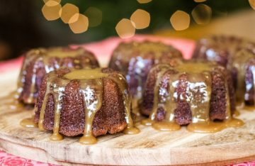 sticky toffee pudding cakes on a board drizzled with toffee sauce