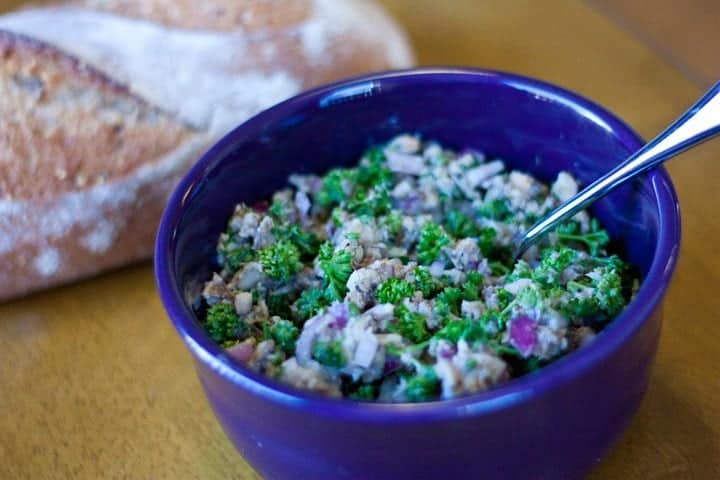 Sardine salad in a blue bowl with bread on the side