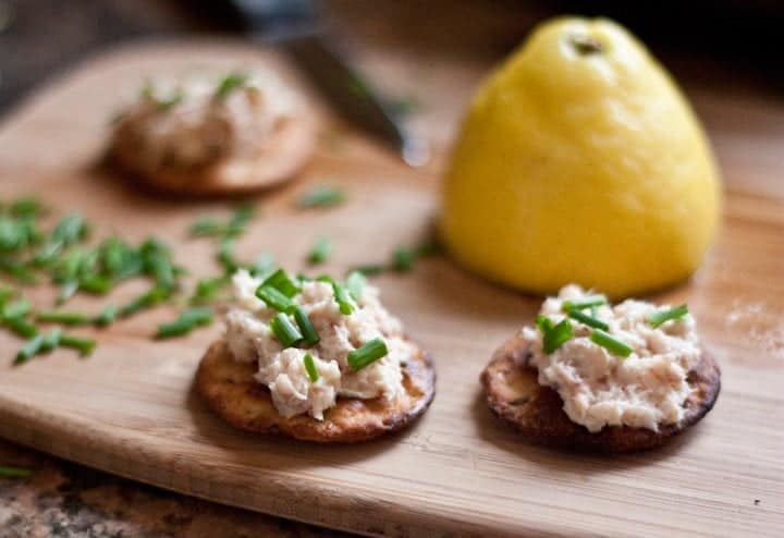 Smoked trout spread on crackers on a cutting board