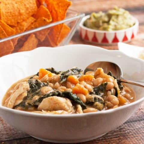 white bean chicken chili in a bowl with garnishes