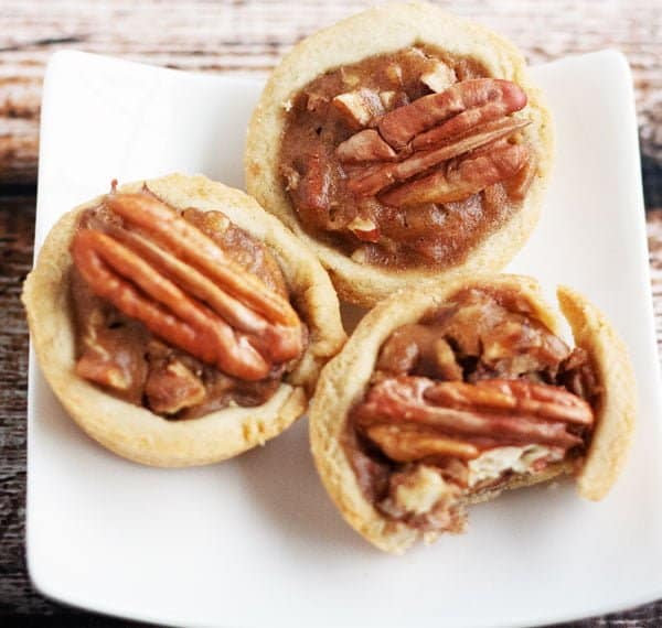 three gluten free pecan pie tartlets on a plate