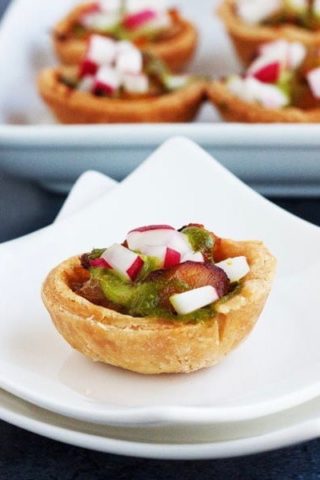 Mexican radishes with salt cod in mini tarts on a white plate.