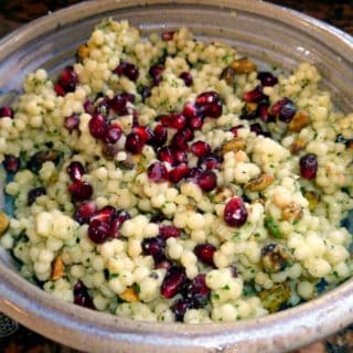 A bowl of Israeli couscous salad with pomegranate.