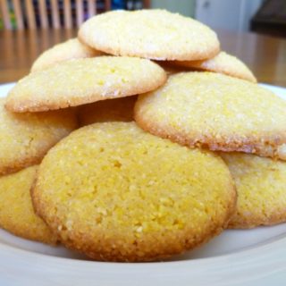 A stack of lemon polenta biscuits on a white plate.