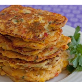 A stack of corn pancakes on a plate.