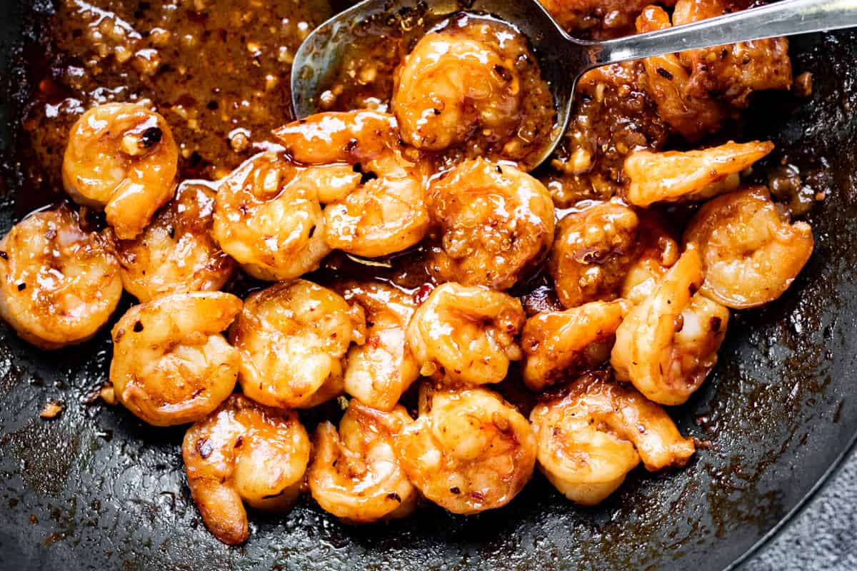 A photograph of cooked Szechuan shrimp in a skillet.