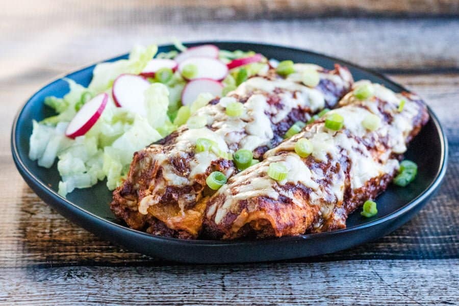 chicken enchiladas with salad on plate