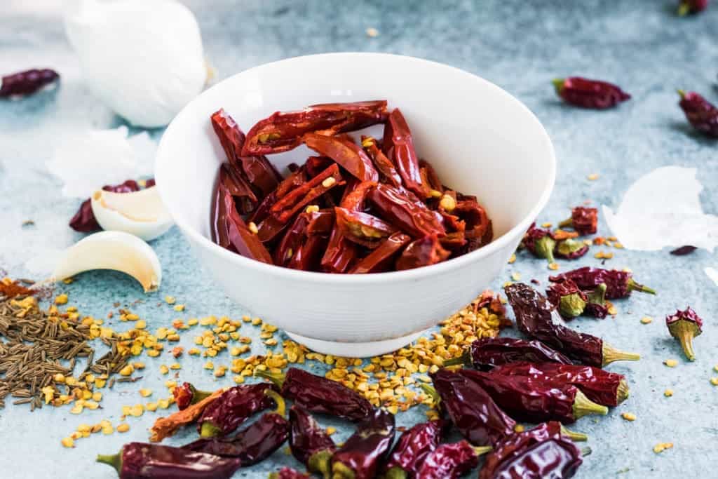 A spicy harissa recipe consisting of chili peppers and garlic in a bowl.