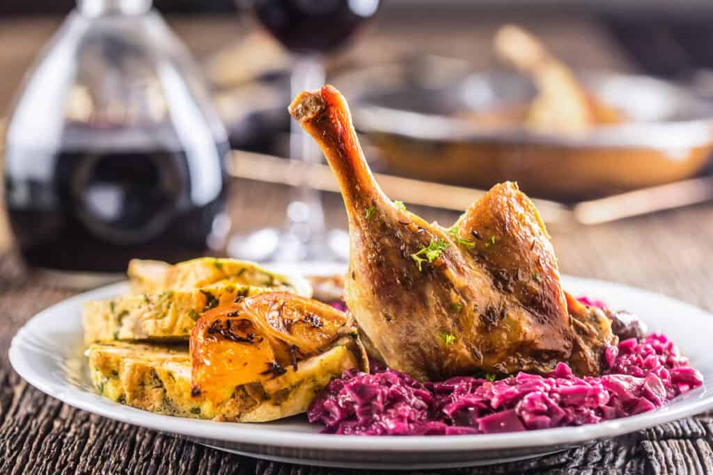 Roasted chicken with red cabbage and wine on a plate.
