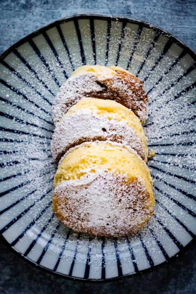 overhead shot of souffle pancakes dusted with powdered sugar on a pretty Japanese plate