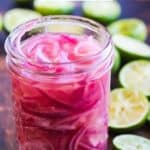 Pickled red onions and lime slices preserved in jar.