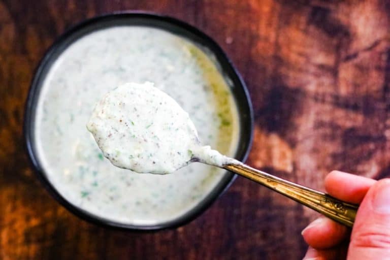Cilantro yogurt chutney in a bowl with a spoonful being lifted out
