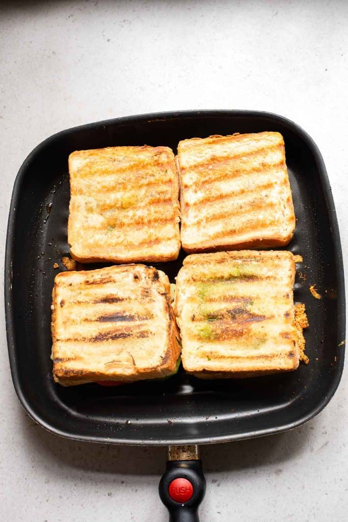 a pan with 4 grilled bombay sandwiches in it.