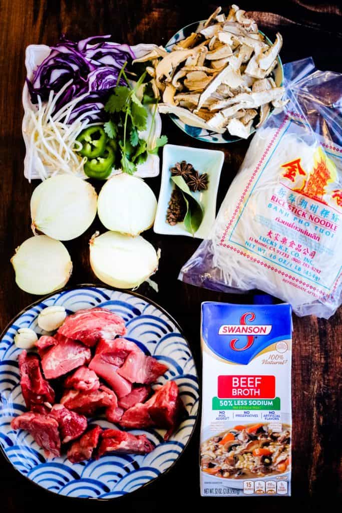 display of ingredients for pho including onion, garlic, noodles, broth, beef