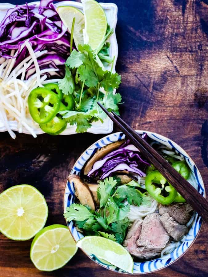 overhead shot of beef pho and garnishes