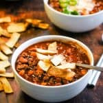 Two bowls of instant pot chili on a wooden table.