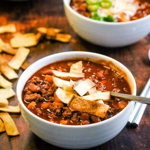 Two bowls of instant pot chili on a wooden table.