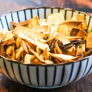 baked tortilla strips in a blue-and-white striped bowl