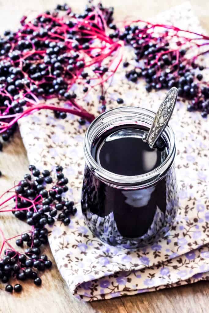 A recipe for elderberry syrup with berries and a spoon.