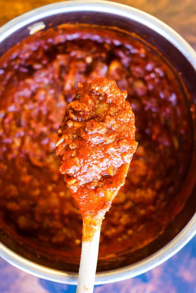 cooked meat sauce in the instant pot with a wooden spoon