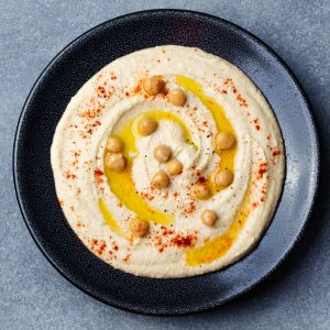 Instant pot hummus with chickpeas on a black plate.