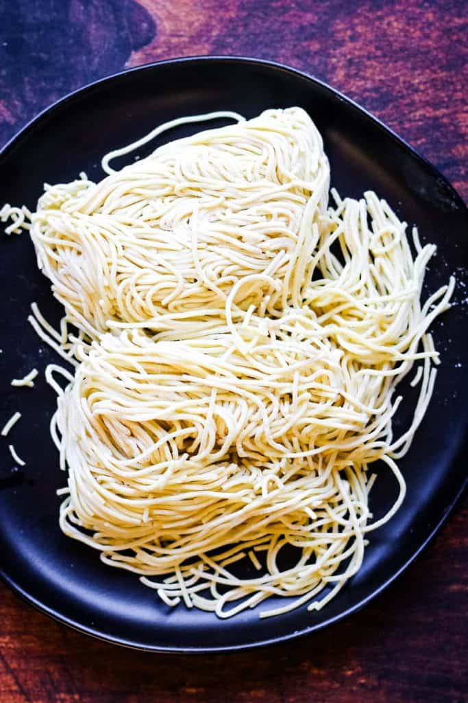 uncooked fresh ramen noodles on a black plate