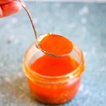 A jar of orange harissa dressing.