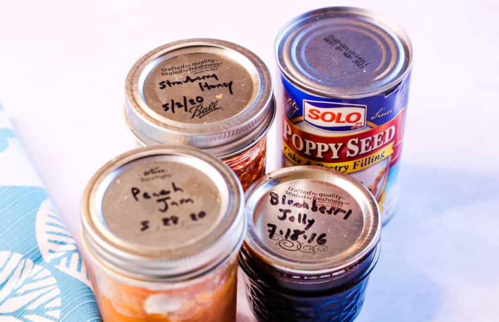 Possible filliings for hamentashen. The photo shows jars of peach jam, blackberry jelly, strawberry honey jam, and a can of solo poppy seed filling.