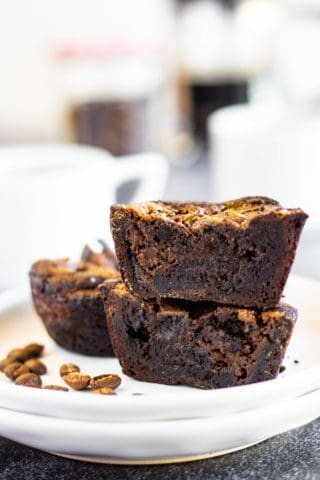A plate of coffee brownies accompanied by a cup of coffee.