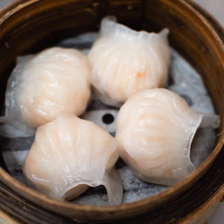 low angle shot of 4 har gow shrimp dumplings in a bamboo steamer