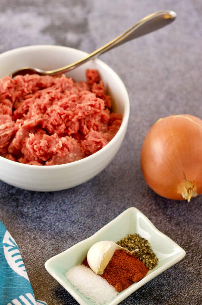 ingredients for beef kreplach filling including ground beef, onion, garlic, salt, pepper, and paprika