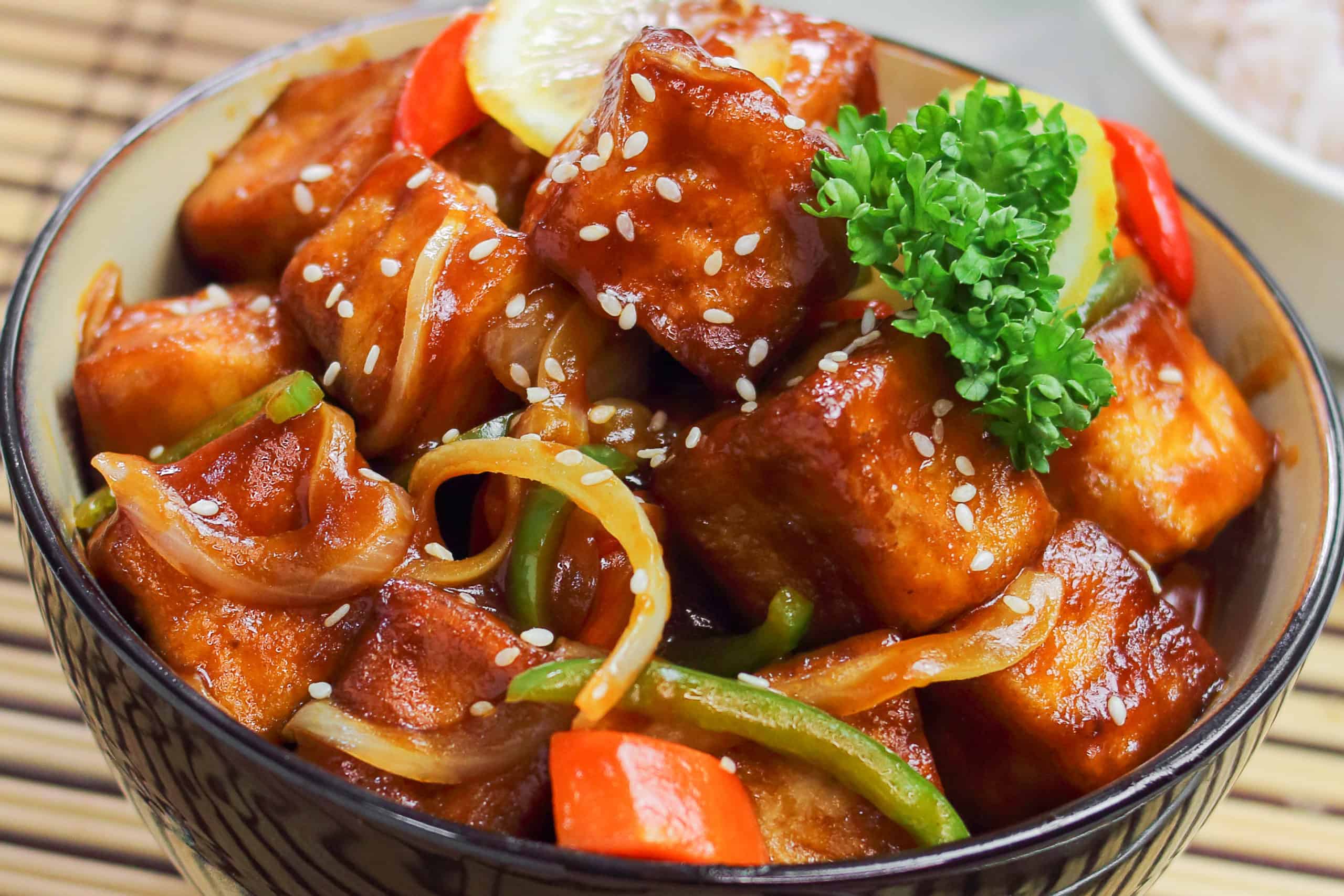 A low-angle shot of Sweet and Sour Tofu in a bowl.