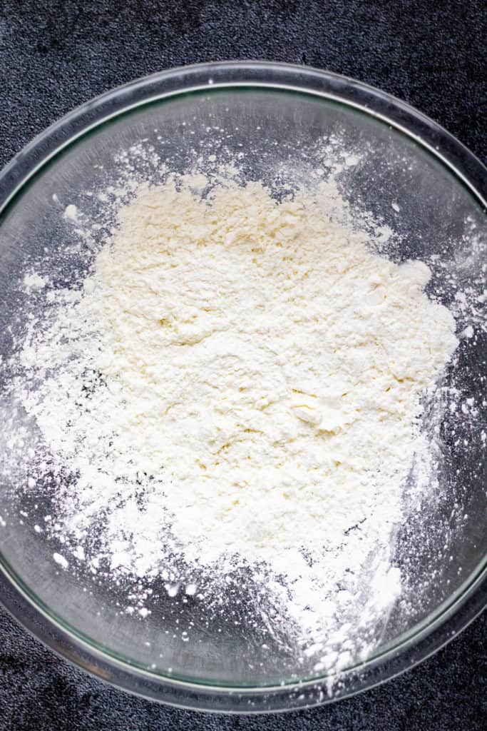 Overhead shot of cornstarch in a large bowl ready to dredge the chicken.