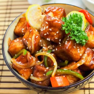 A low-angle shot of Sweet and Sour Tofu in a bowl.