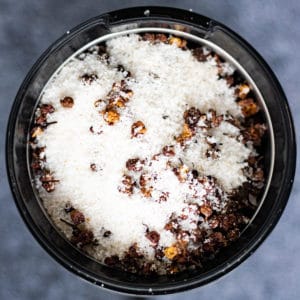 Overhead shot of toasted szechuan peppercorns and salt in a spice grinder.