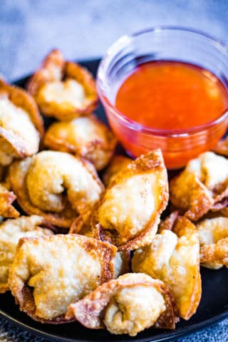 Low angle shot of fried wontons with dipping sauce.