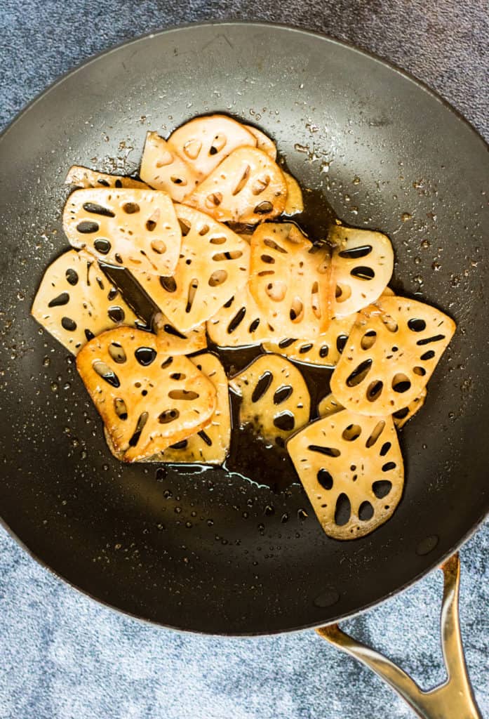 A Japanese recipe featuring fried yams and lotus root cooked in a frying pan.