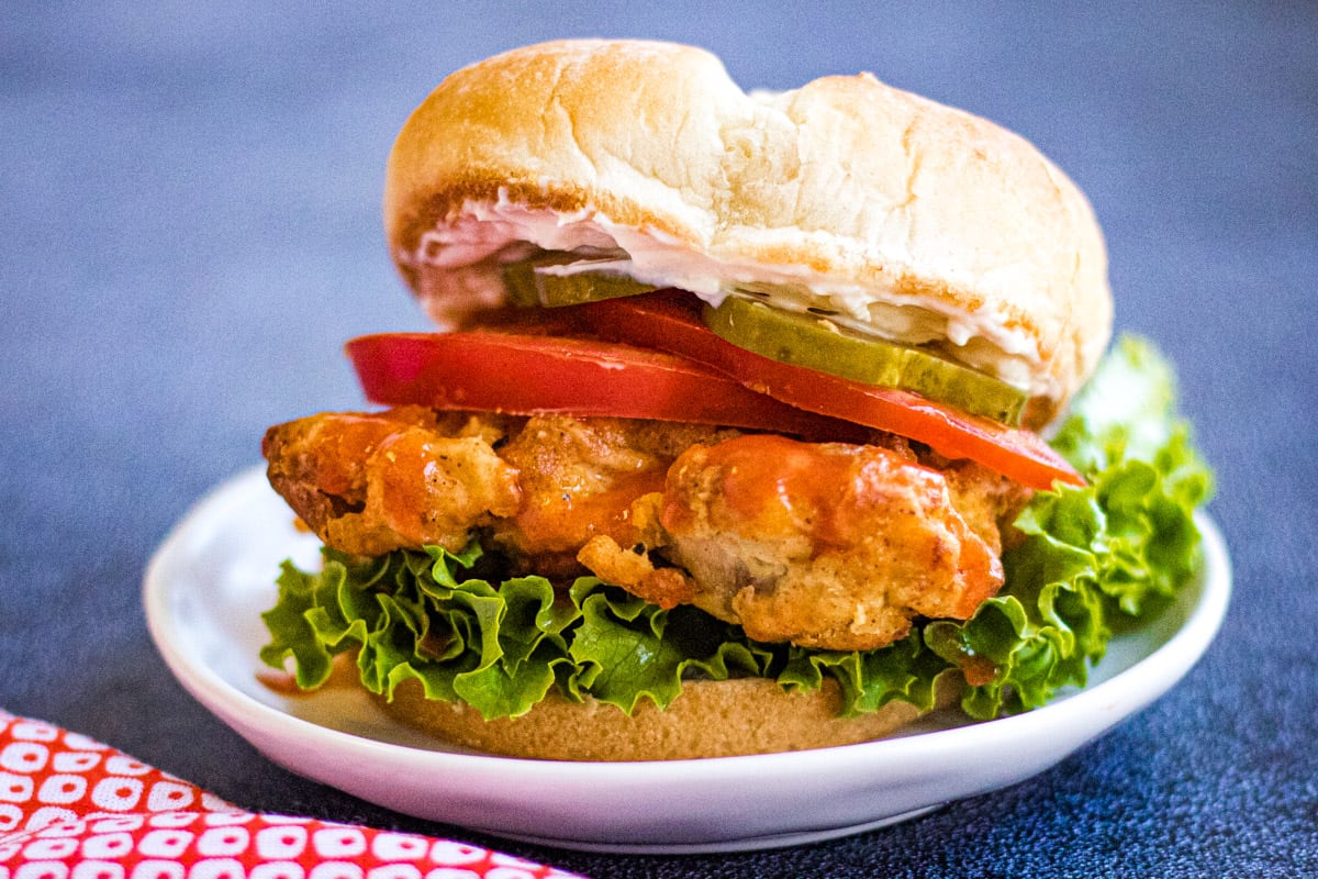 Low angle shot of an air fryer chicken sandwich on a white plate.