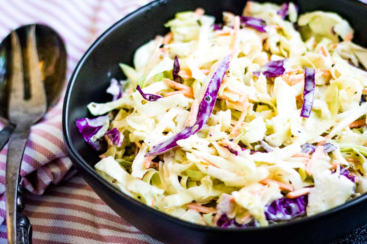 low angled shot of coleslaw in a black bowl.