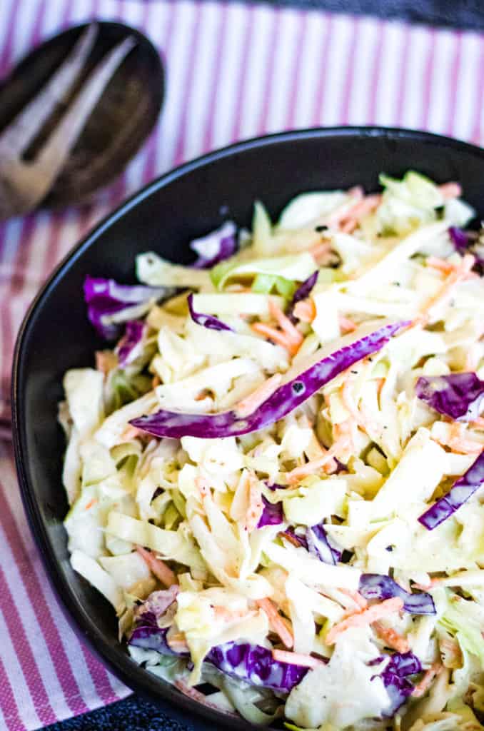 low angle shot of the coleslaw in a black bowl.
