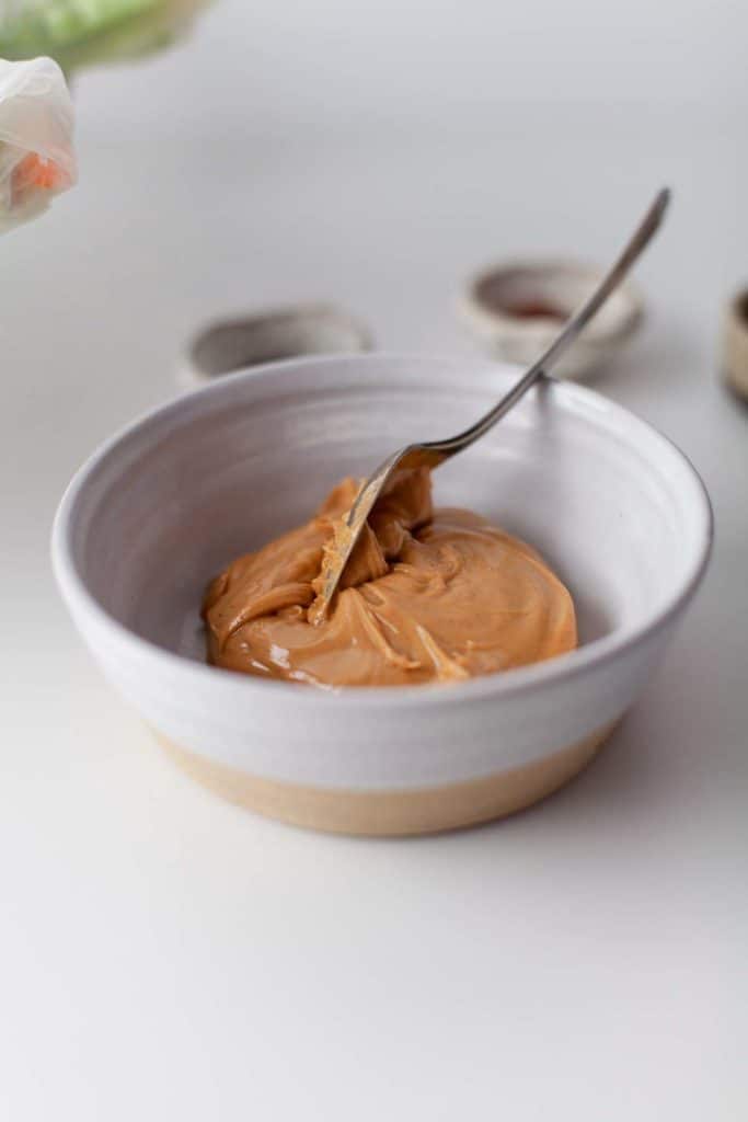 Peanut butter sauce in a white bowl.