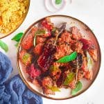 Two bowls of chicken 65 and rice on a table.