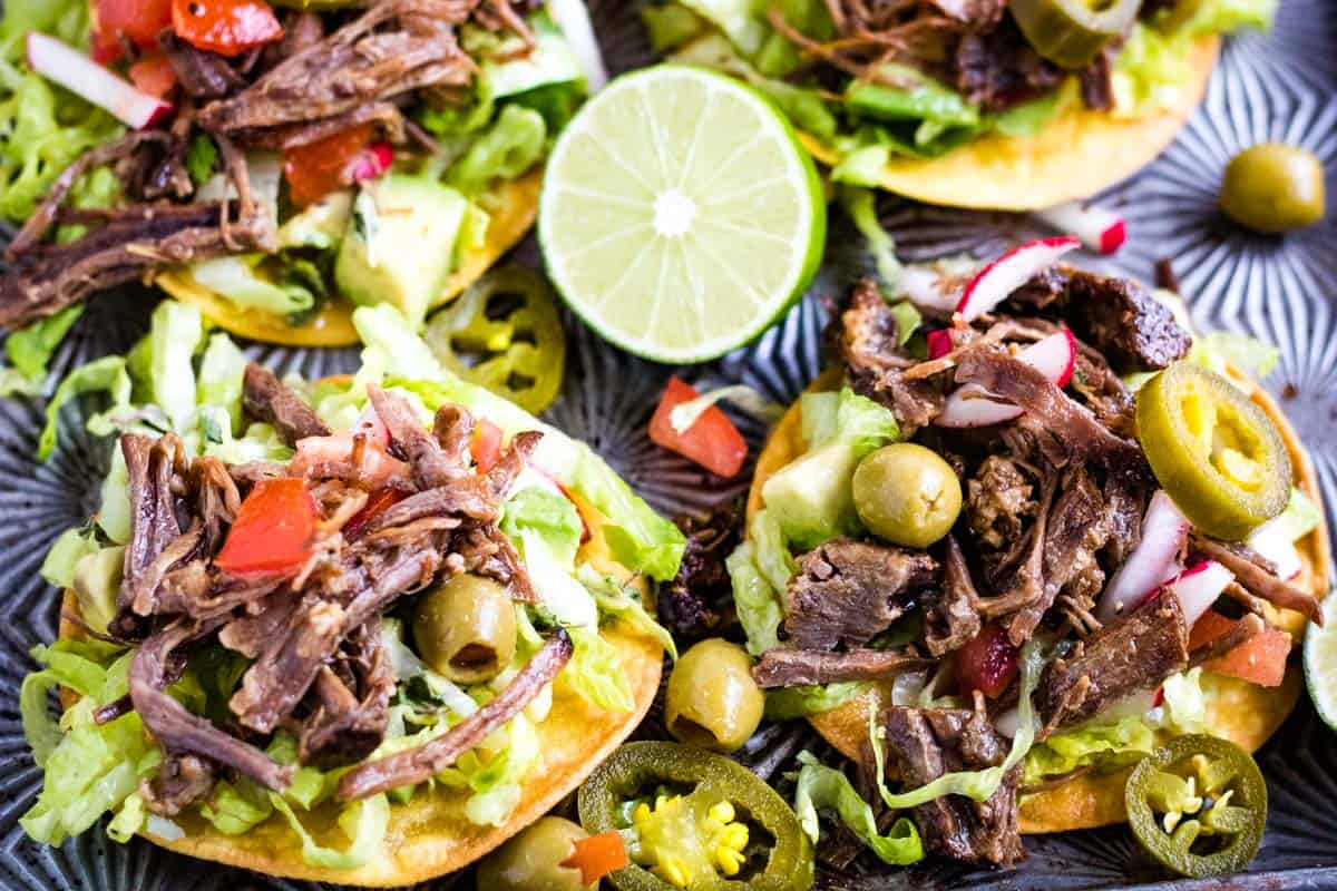 Low angle shot of salpicon de res or Mexican shredded beef salad on tostada shells.