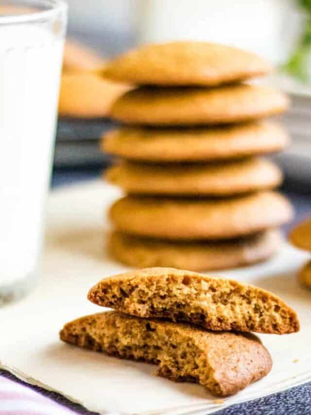A stack of cookies next to a glass of milk.