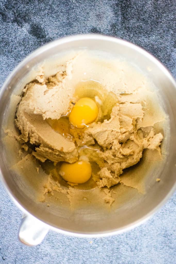 Two eggs and honey in a mixing bowl.