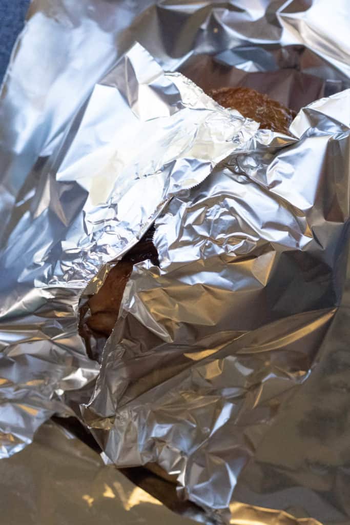 A foil-wrapped piece of bread on a table.