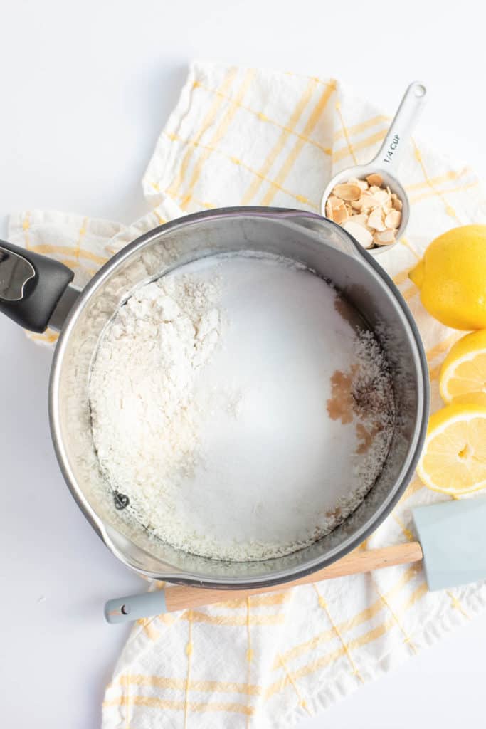 A pan with flour and lemons next to coconut macaroons.