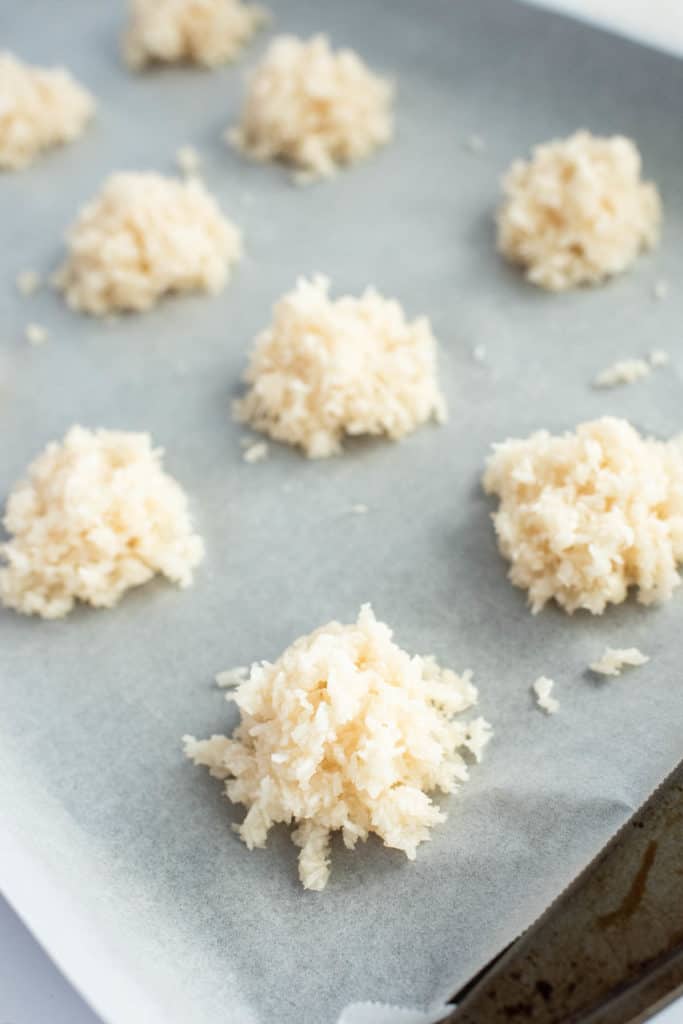 Rice krispies and coconut macaroons on a baking sheet with a knife.