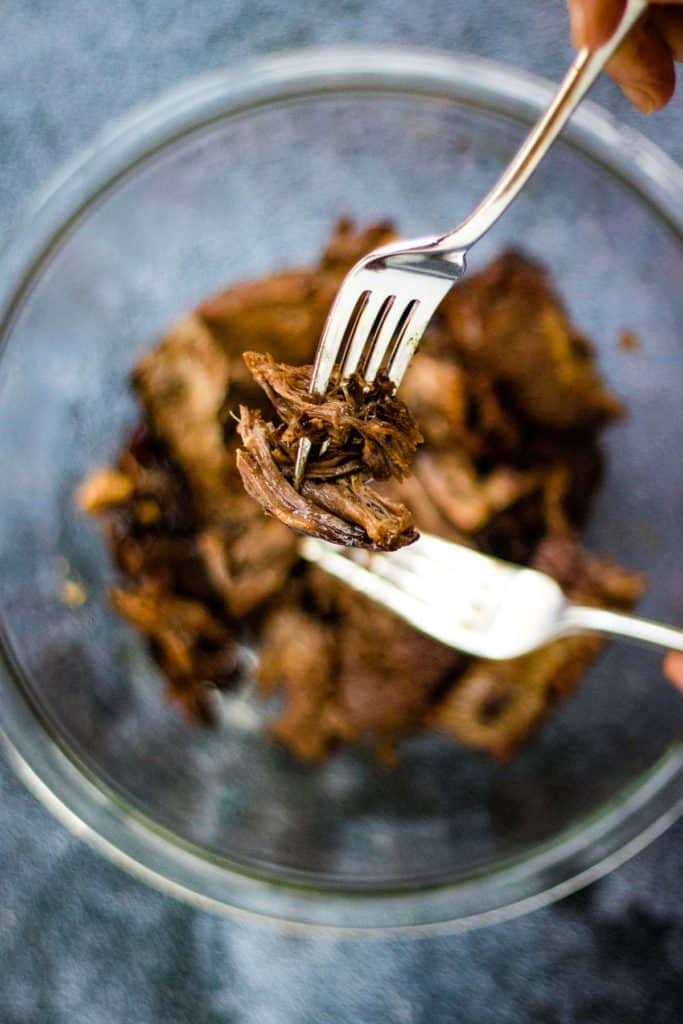 Overhead shot of Mexican shredded beef between two forks